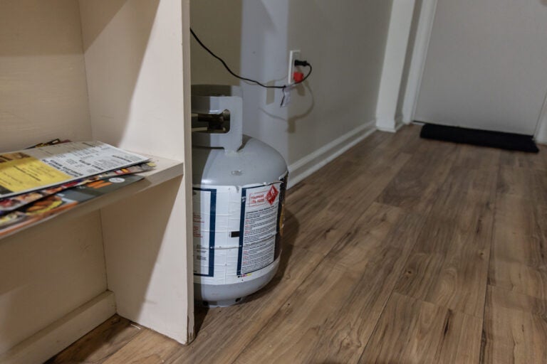 A propane tank sitting on the floor in someone's apartment