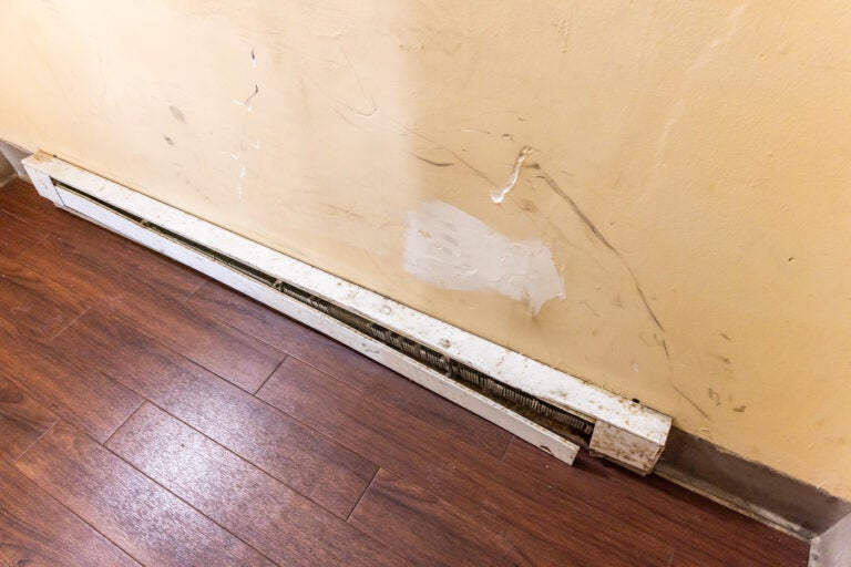 A baseboard heater is shown in an apartment building