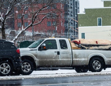 a truck drives in a snowy street