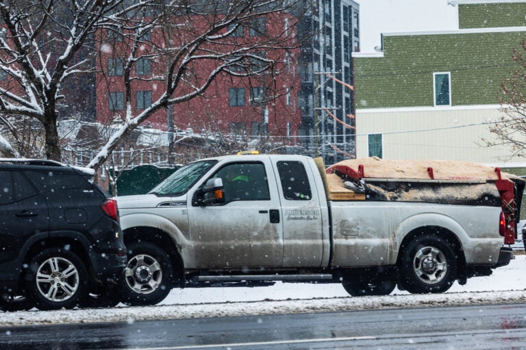 a truck drives in a snowy street