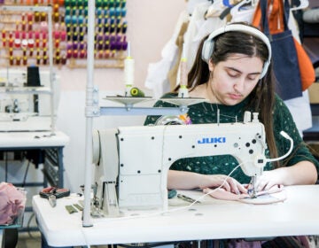 a worker stitches clothes