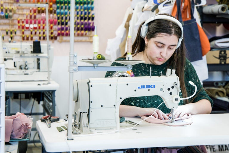 a worker stitches clothes