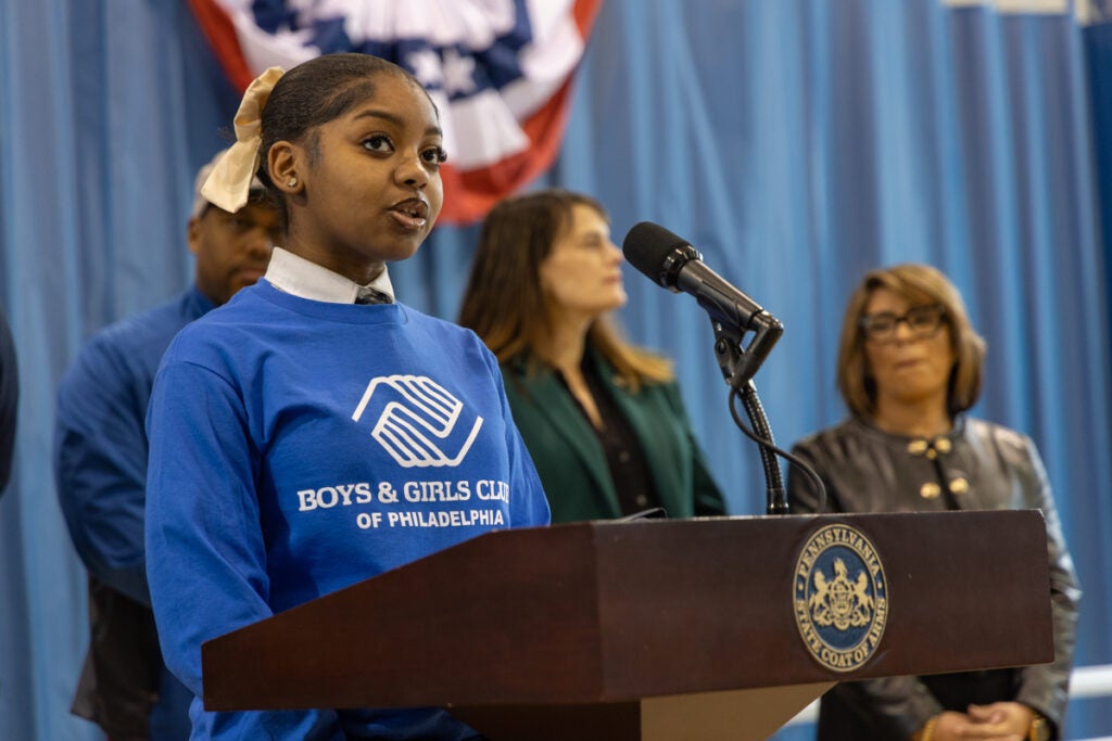 Maya Johnson speaks behind a podium