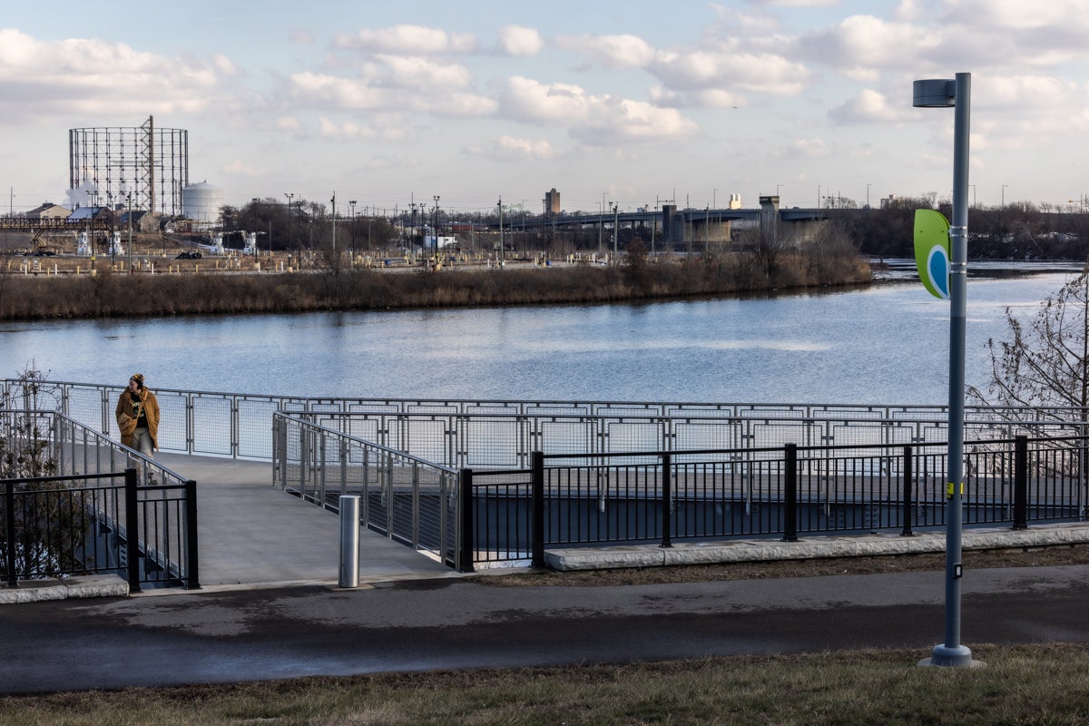 a person walking on the trail by the river