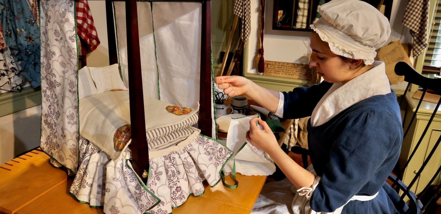 Nina Gold hand-sews bedding for a miniature bed