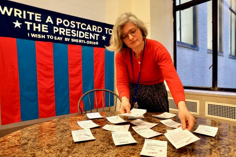 A woman displays postcards sent to United States presidents