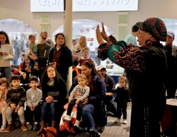 Parents and children listen to Queen Nur