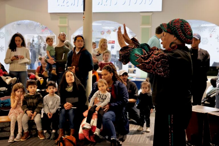 Parents and children listen to Queen Nur