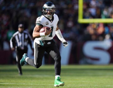 Philadelphia Eagles quarterback Jalen Hurts (1) running with the ball during the first half of an NFL football game against the Washington Commanders, Sunday, Dec. 22, 2024, in Landover, Md. (AP Photo/Stephanie Scarbrough)