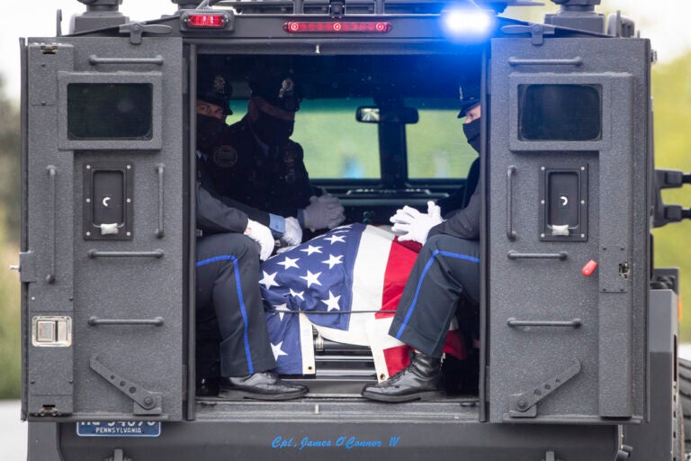 FILE - Police officers wearing a protective face masks as a precaution against the coronavirus accompany the remains of Cpl. James O'Connor as they depart from Our Lady of Calvary Church in Philadelphia, Friday, May 8, 2020. O'Çonnor was shot and killed early Friday, March 13, as he served a homicide warrant at a home in the Philadelphia's Frankford section. (AP Photo/Matt Rourke, File)