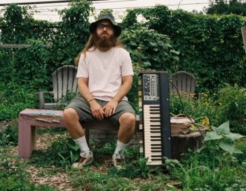 Corey Bernhard sitting outside with a keyboard