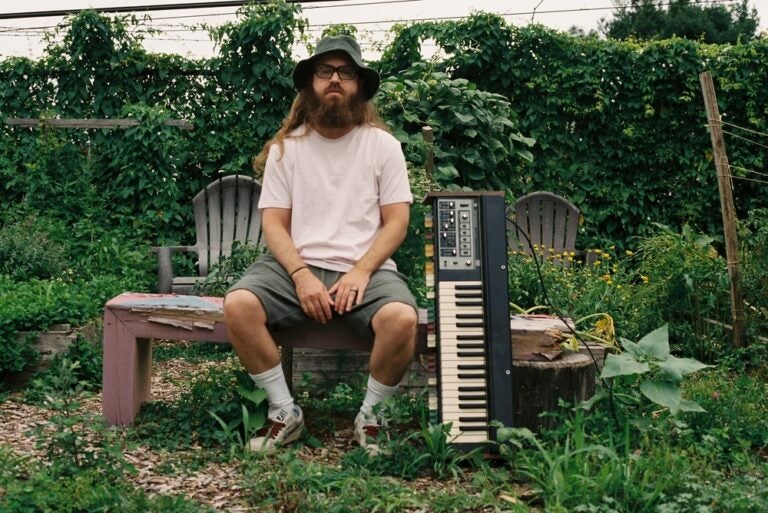 Corey Bernhard sitting outside with a keyboard