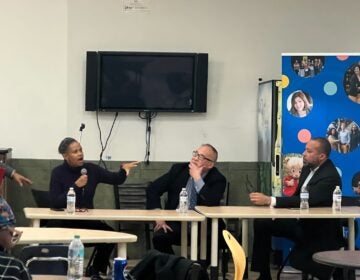 Panelists sitting at a table during a conversation