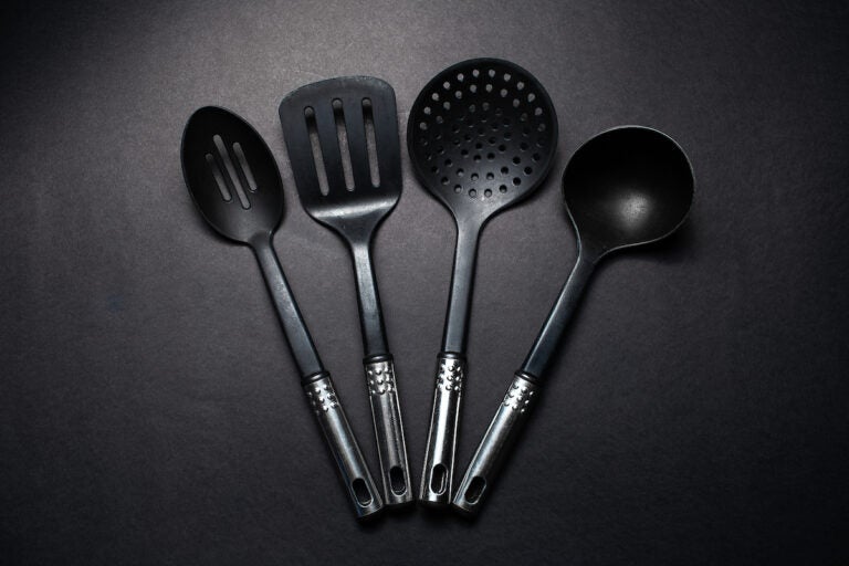 Studio picture of black plastic kitchen utensils with chromed handles. (Bigstock/Lalandrew)