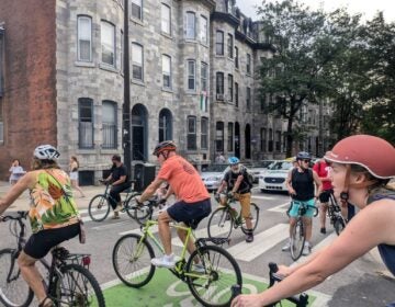 Several people on bicycles block a busy intersection