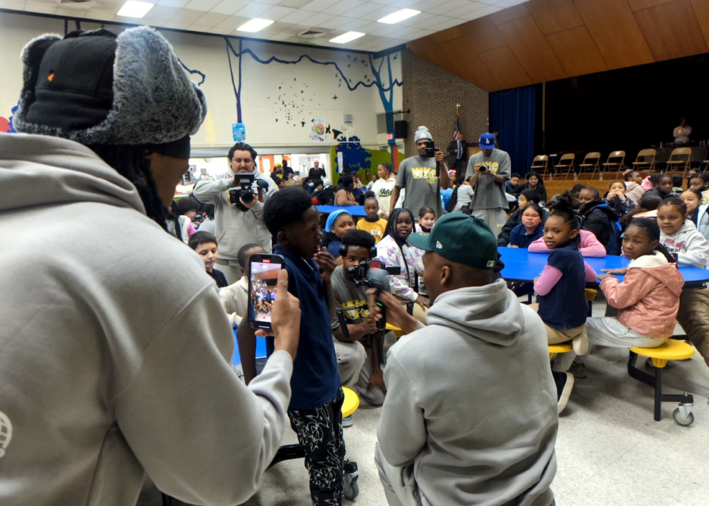 DJ Deezy addressing a room full of school children