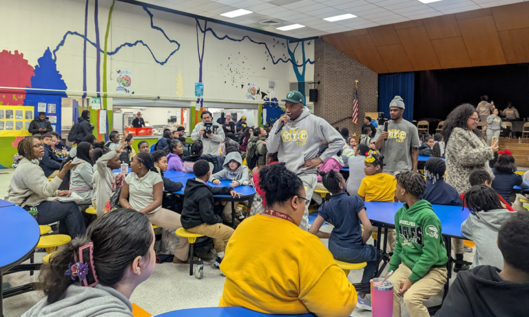 DJ Deezy addressing a room full of school children