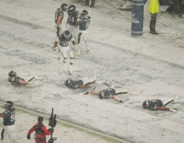 Four Eagles players do snow angels