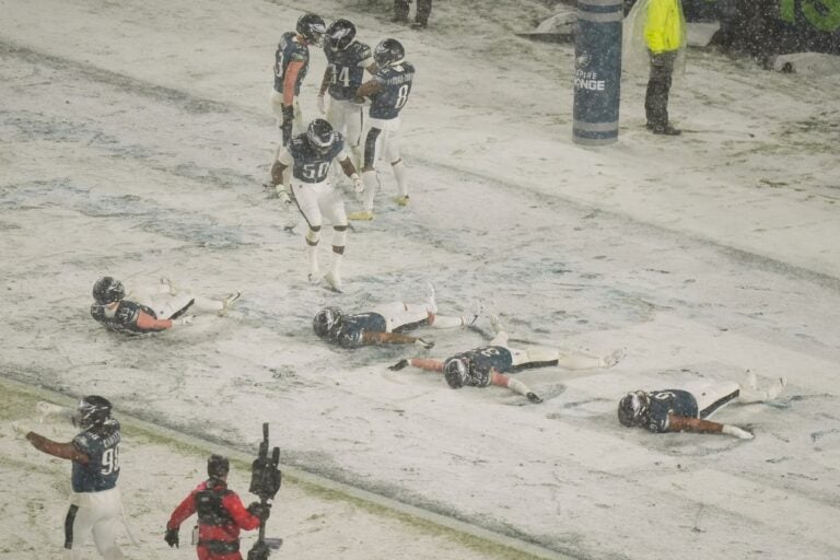 Four Eagles players do snow angels