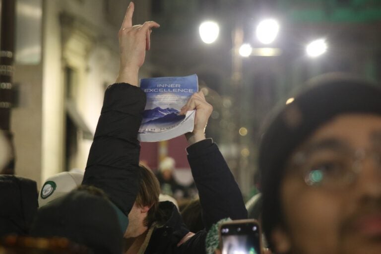 a fan holds the book Inner Excellence in the air