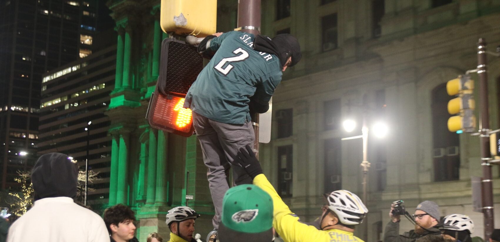 a fan climbs a pole