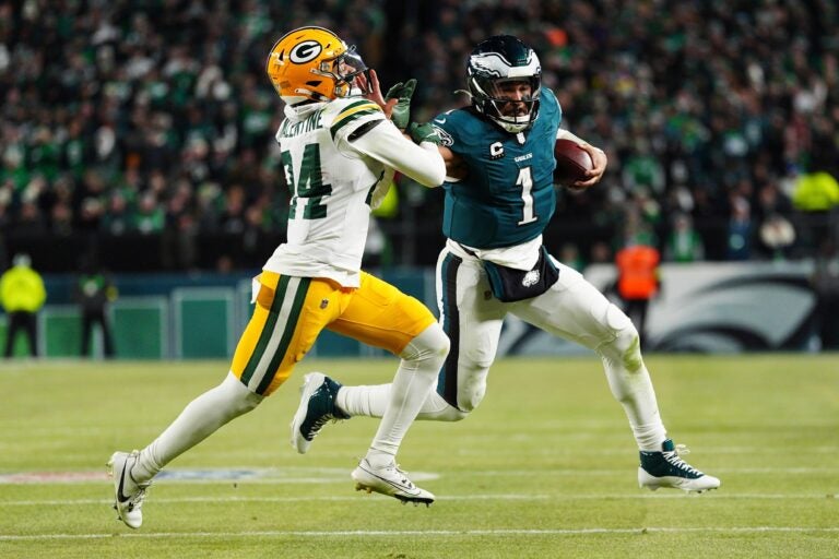 Jalen Hurts stiff-arms a Packer