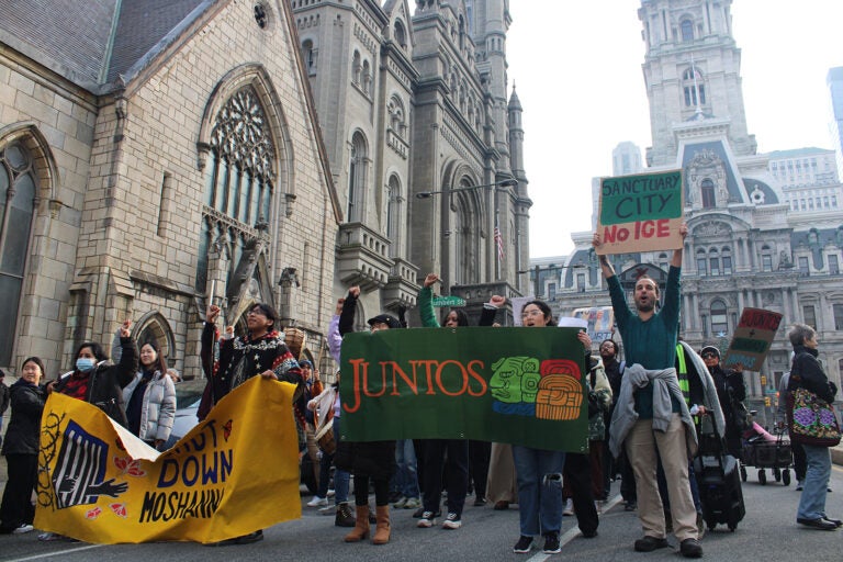 Dozens rallied at City Hall on Dec. 10, 2024, calling on Philadelphia elected officials to reaffirm sanctuary city protections for undocumented residents. (Emily Neil/WHYY)