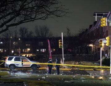 Police and firefighters respond at the scene after a small jet crashed into homes in Northeast Philadelphia