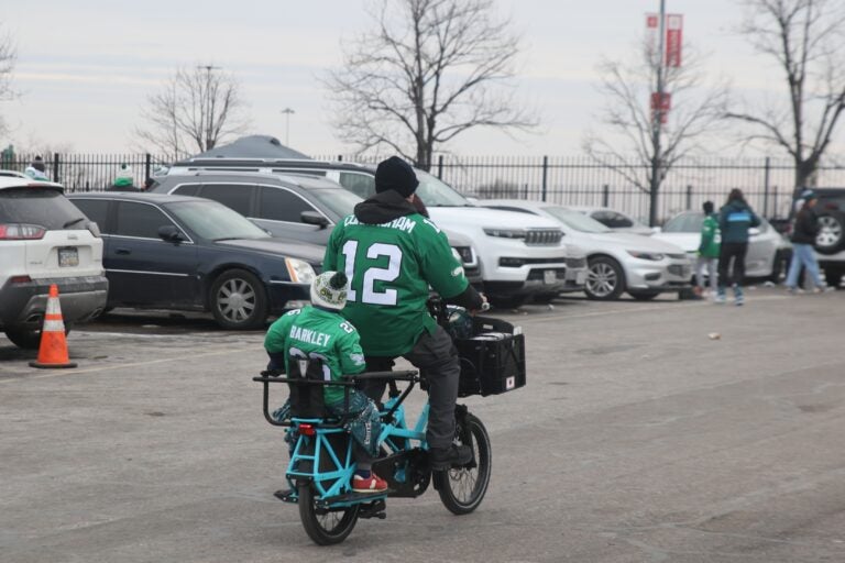 a man and child in Eagles gear on a bike