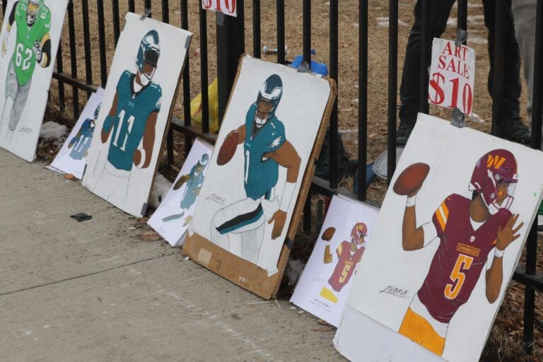 drawings of Eagles and Commanders players against a fence