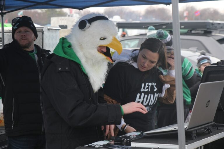 a DJ in an Eagle mask on a computer