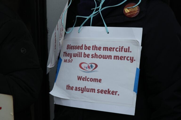 a sign reads Blessed be the merciful. They will be shown mercy. Mt. 5:7 Welcome the asylum seeker.