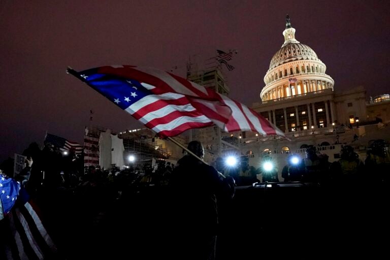 Protesters hold flags with the 13 Colonies