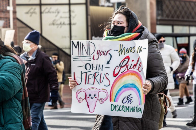 a protester holds a sign reading MIND YOUR OWN UTERUS THERE'S NO PRIDE IN DISCRIMINATION