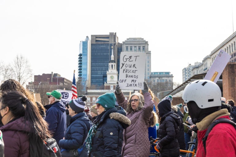 protesters walking. one sign reads GET YOUR FASCIST HANDS OFF MY DATA!!!