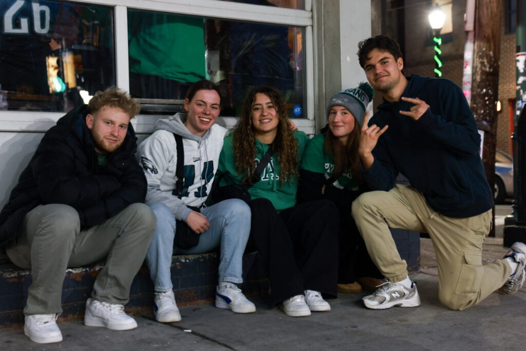 Five people in Eagles gear smile