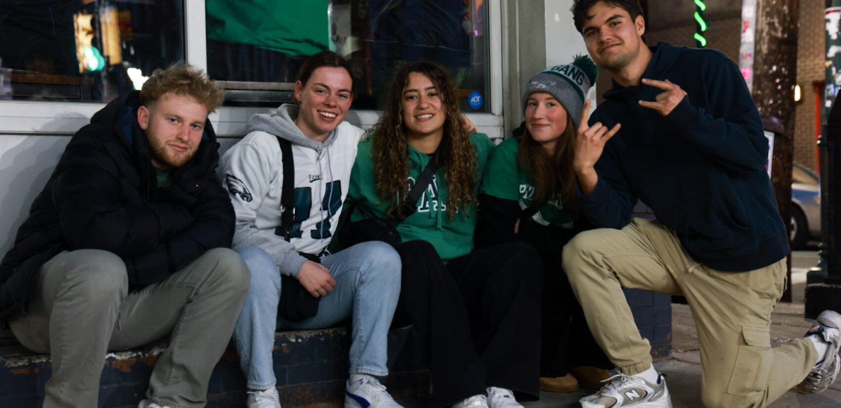 Five people in Eagles gear smile