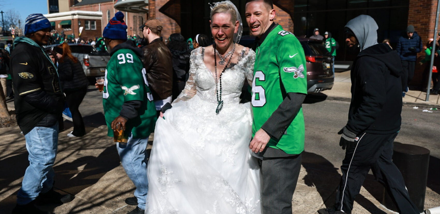 A man in an Eagles jersey with his bride in her wedding dress