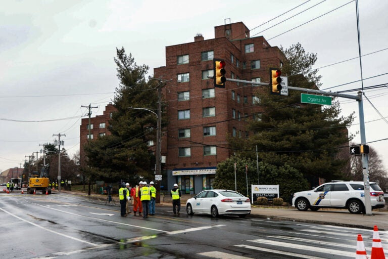 Workers standing in the street in front of an apartment building