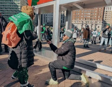 Nicholas Maestrale got down on one knee to pop the question to Olivia Dees during the Eagles victory parade. (Peter Crimmins/WHYY)
