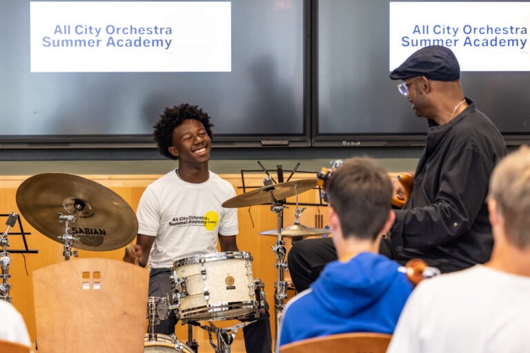 A teenager playing the drums while Gerald Veasley plays the bass