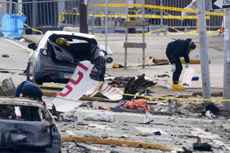 Investigators work the scene after a small plane crashed in Philadelphia, Saturday, Feb. 1, 2025. (AP Photo/Matt Rourke)