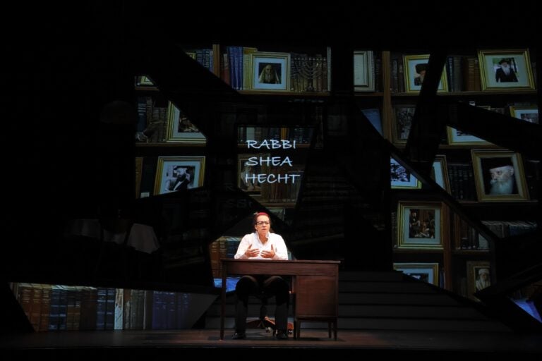 Phyllis Johnson performs onstage at a desk