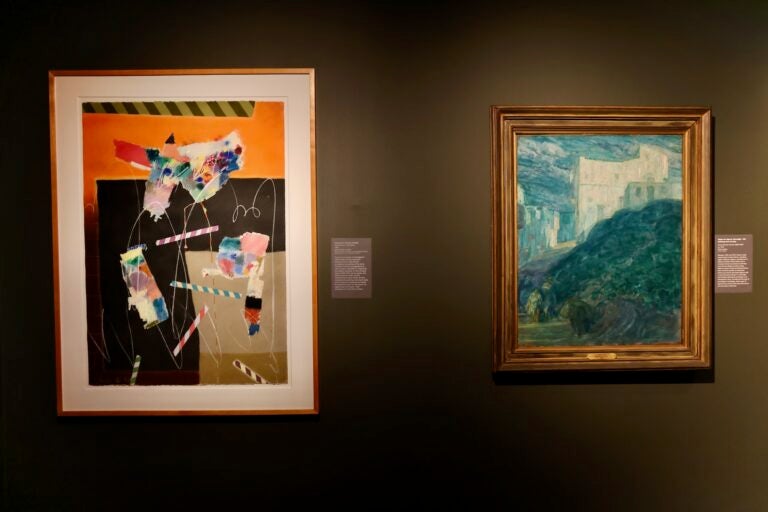 2 paintings hung up on a wall in an exhibit