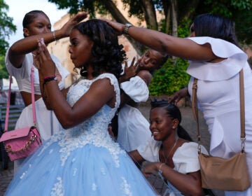 Friends and family fuss over a quinceañera in preparation for her photo session at Colon Square in the Zona Colonial neighborhood of Santo Domingo, Dominican Republic, May 15, 2024. (AP Photo/Matias Delacroix)