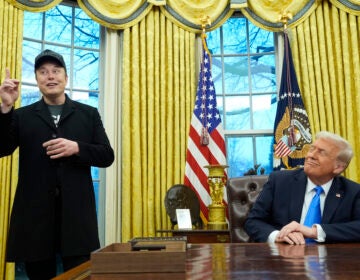 Donald Trump listens as Elon Musk speaks