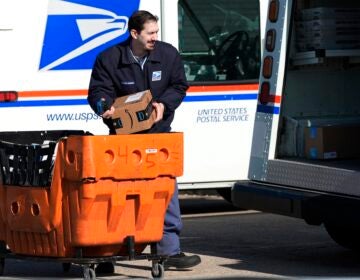 A postal worker loading up a mail truck