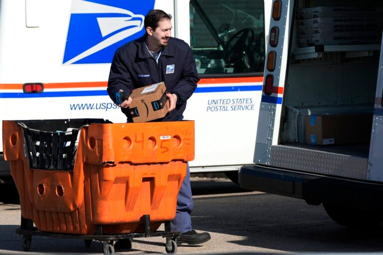 A postal worker loading up a mail truck