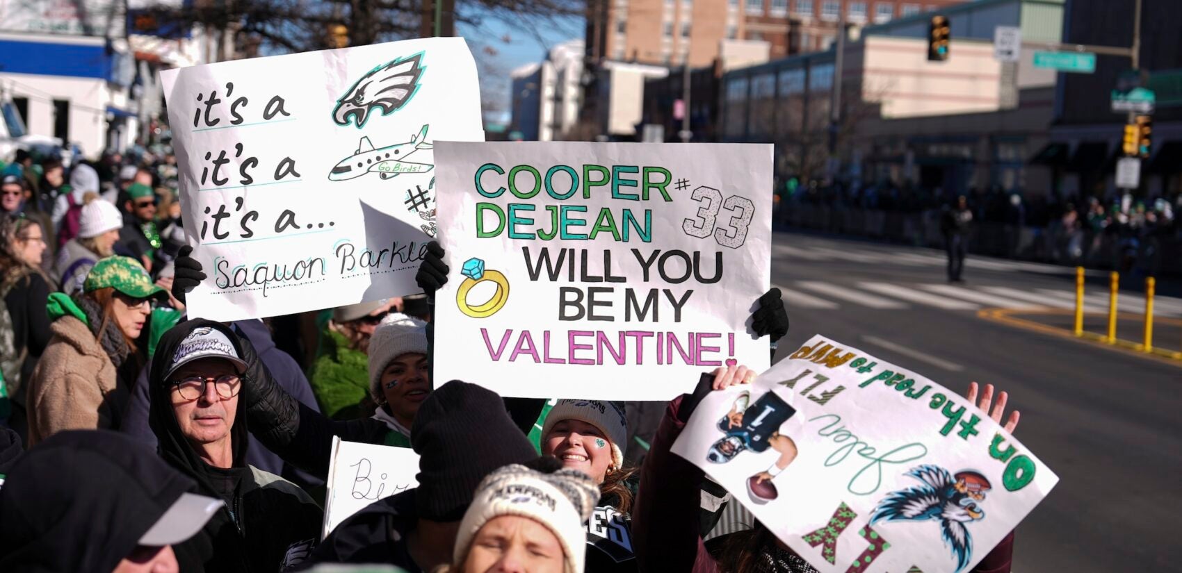 Fans holding up signs along the parade route