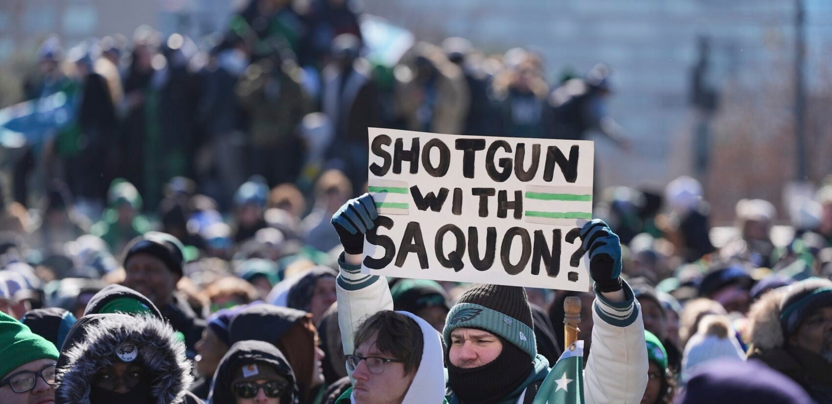 A fan holds up a sign saying 'Shotgun with Saquon?'